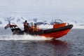 Orange boat sailing at high speed in Antarctic waters against mo