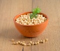 Orange bowl full of chickpeas Legume with plant on wooden background