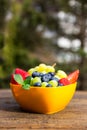 Orange bowl on wooden table, fresh seasonal fruits inside Royalty Free Stock Photo