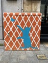 An orange box painted with white lattice and blue silhouette of a cat playing with a butterfly Royalty Free Stock Photo