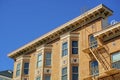 Orange brick building facade with flat roof design and visible windows with metal escape ladder and balcony and clear Royalty Free Stock Photo