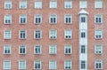 Orange brick wall vintage building. Glass window of skyscraper apartment or hotel building. Exterior brick wall of residential Royalty Free Stock Photo