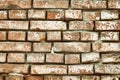 Orange brick wall with weathered cement slurry texture