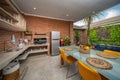 Orange brick walls. Luxury villa in a modern design. Open space dining with pool view next to livign room Royalty Free Stock Photo