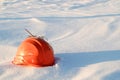 An orange broken construction helmet lying