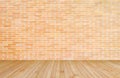 Orange-brown brick wall with wood floor in yellow brown background of interior decoration Royalty Free Stock Photo