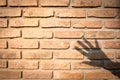 Orange brown old brick wall texture with hand shadow. concept Background for design