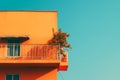 an orange building with a balcony and a plant on the balcony