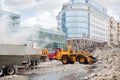 Orange bulldozer loads wet snow to trucks for snow melting Royalty Free Stock Photo