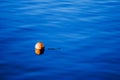 Orange buoy on blue sea water