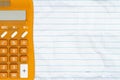 Orange calculator on wrinkled lined paper background Royalty Free Stock Photo