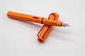 Orange calligraphic or fountain pen isolated on white background Royalty Free Stock Photo