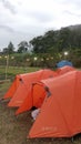 orange camping tent on the edge of the lake