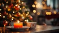 Orange Candle holder with some Christmas crockery put on a wood table with a blurry luminous Christmas tree