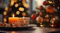 Orange Candle holders with some Christmas decorations put on a wood table with a blurry red and gold Christmas tree