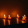 Orange Candles Glow in Dark on Wooden Table Royalty Free Stock Photo