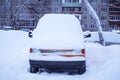 Orange car, van covered snow after snowfall and blizzard on town street in winter Royalty Free Stock Photo