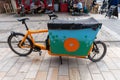 An orange cargo delivery bicycle in the Fruit Market area of the city of Kingston upon Hull, UK
