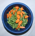 The orange carrot and green bean in the bowl. Top view with white background
