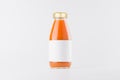 Orange carrot juice in glass bottle with gold cap and white blank label mock up on white background with copy space, template. Royalty Free Stock Photo