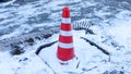 Orange caution cone in snow