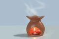 orange ceramic oil burner There is a fragrance written inside. Placed on a white-gray background Royalty Free Stock Photo