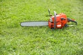 orange chainsaw on grass