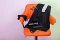 orange chair against the wall, for the hairdresser, with a set of tools for cutting, with Cape and clips.