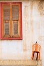Orange chair hanging on the wall and beautiful wooden window of a traditional house in the old city of Nicosia, Cyprus Royalty Free Stock Photo