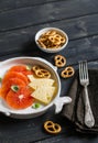 Orange, cheese and crackers on a white plate on a dark wooden surface Royalty Free Stock Photo