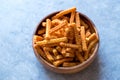 Orange Cheese Flavored Corn Snacks in Stick Shape / Roasted Chips or Salty Crackers in Wooden Bowl. Royalty Free Stock Photo