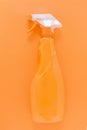 Orange chemical bottle on monochrome background. Clean up concept. Flat lay of domestic cleaning kit.