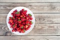 Orange cherry with green branches on a white plate Royalty Free Stock Photo