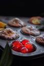 Orange and cherry muffins in muffin baking pan Royalty Free Stock Photo