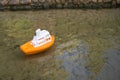 Orange children's toy ship floating on the river