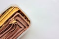 Orange and chocolate ice cream in a plastic box on white background with copy space. Selective focus