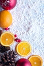 Orange christmas fruit with cinnamon and star anise spice, mistletoe and snow background.