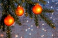 Orange Christmas ornaments on spruce branches on a shiny blue-silver background. New Year`s or Christmas background Royalty Free Stock Photo