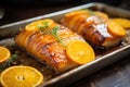 orange citrus marinated pork belly on a metal sheet