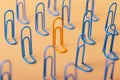 Orange clip among the blues, unlikeness to others, the concept of individuality, optimism, creative idea with office paper clips, Royalty Free Stock Photo