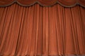 Orange closed curtain or drapes in theater with copy space. Theatrical performance concept.