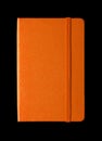 Orange closed notebook isolated on black