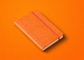 Orange closed notebook isolated on color background