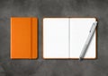 Orange closed and open lined notebooks with a pen on dark concrete background Royalty Free Stock Photo