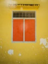 Orange closed window in old wall