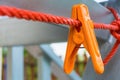 Orange clothes peg hanging on clothes line Royalty Free Stock Photo