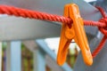 Orange clothes peg hanging on clothes line Royalty Free Stock Photo