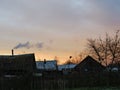 Orange sky during sunset. Smoke from a chimney against a orange sky