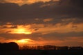 Orange clouds at sunset over silhouettes trees Royalty Free Stock Photo