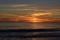 Orange cloudy sunset over the calm ocean